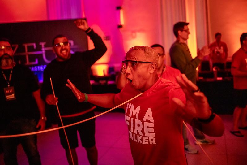 Participante de camisa vermelha I'm a Fire Walker em vivência de forte impacto emocional